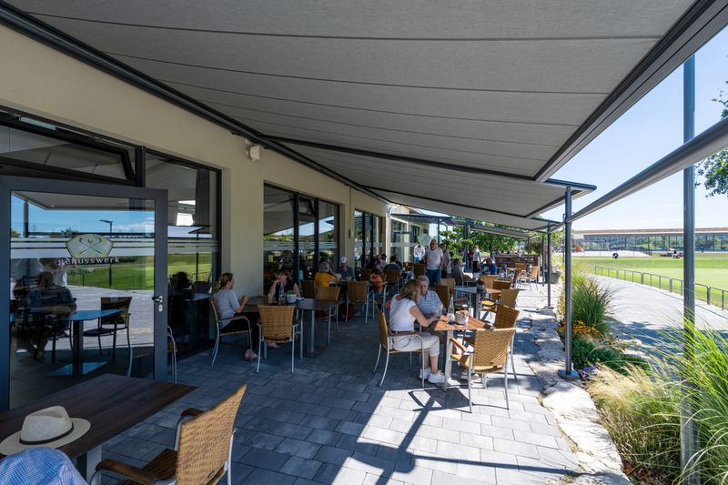 Reference image of several anthracite-colored pergola classic awnings over the outdoor restaurant area of a golf course in Karlsruhe