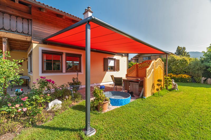 reference markilux pergola classic with red fabric cover in a private garden