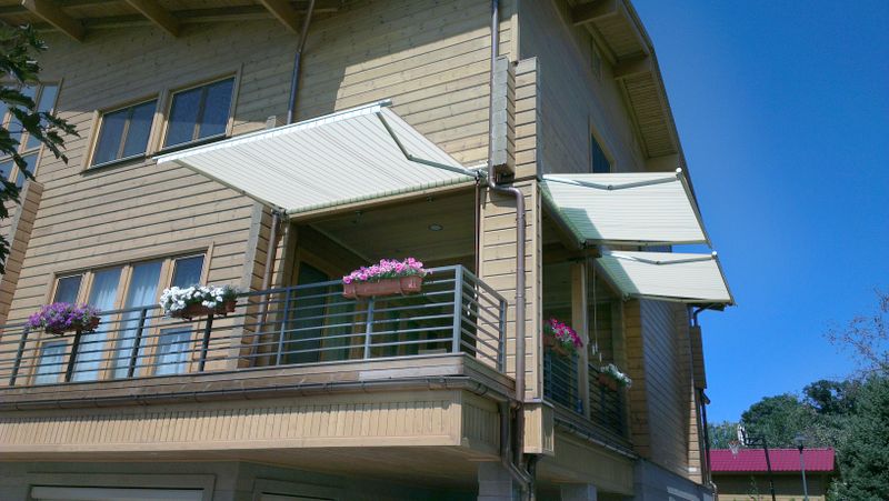 3 tende da sole markilux 930 sul balcone angolare coperto di una casa in legno