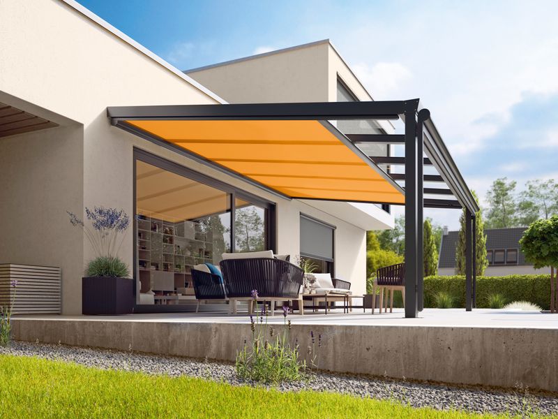 Underglass awning markilux 879 with yellow fabric cover under a patio roof on a single-family house.