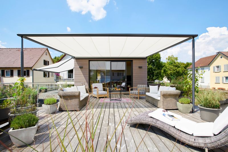 markilux pergola classic de referência com cobertura de toldo branco sobre uma casa de madeira no terraço do telhado.