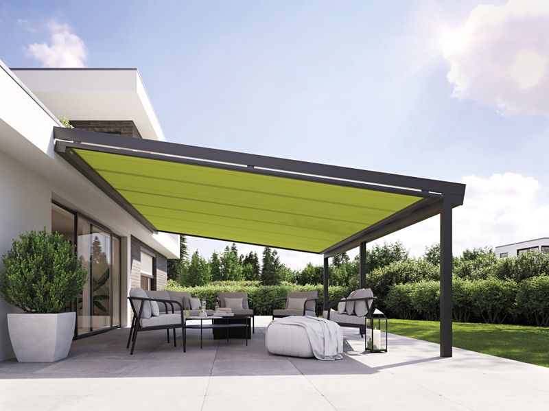 Underglass awning markilux 779 with green fabric cover under a patio roof on a single-family house.