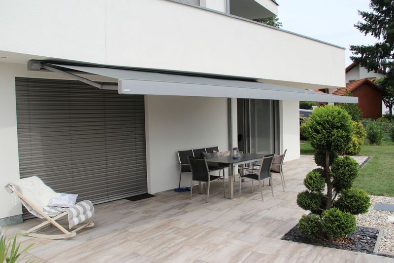 Cassette awning markilux 970 in gray on white plastered terrace wall