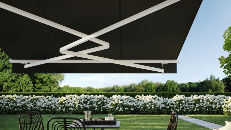 Folding arm awning markilux 1700 in white with dark fabric as stretch variant