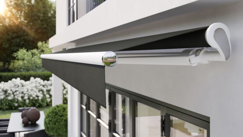 Folding arm awning markilux 1700 with white frame and chrome elements