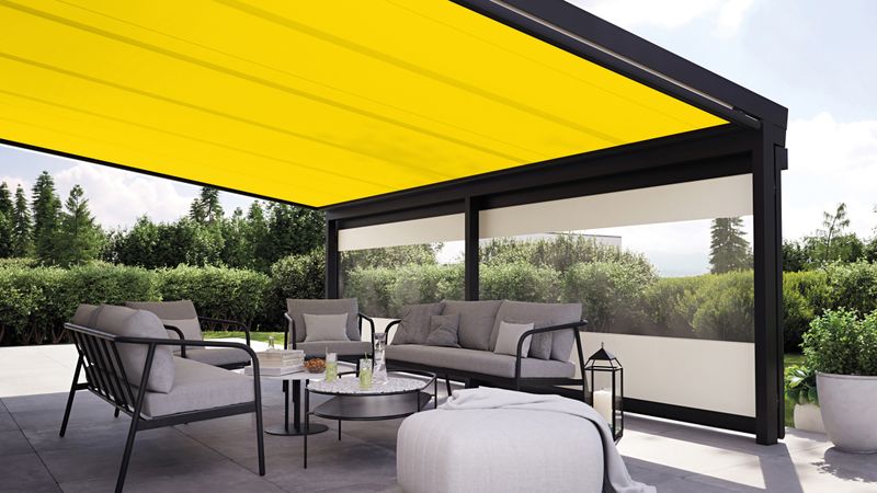 Yellow conservatory awning on a patio roof and frontal is vertical blind with panoramic window.