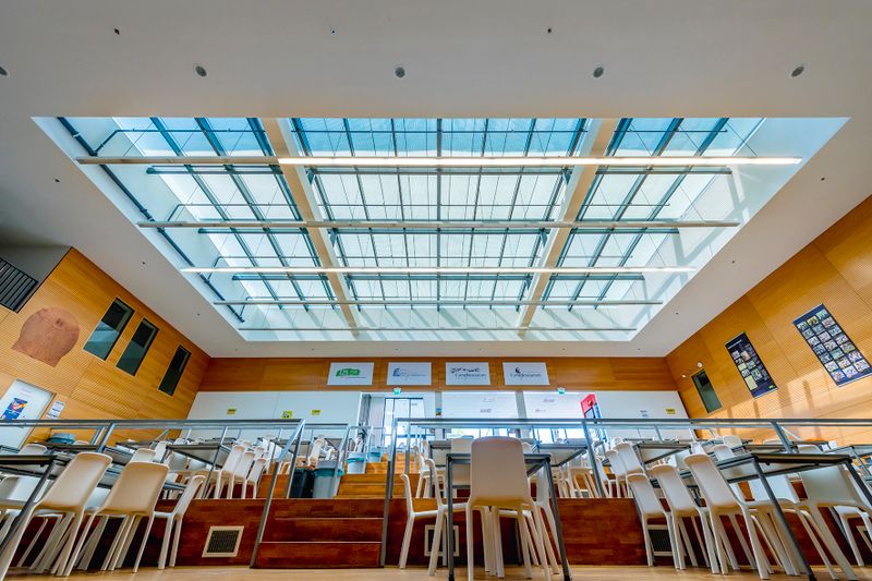 Referentiebeeld op glazen scherm markilux 8800 boven een groot dakraam van een school