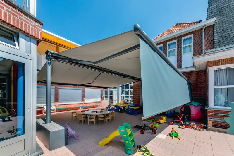 Reference image of a markilux syncra flex above the play area of a kindergarten in Hoogstraten