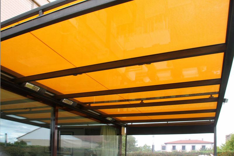 Terrassendach ausgestattet mit einer Aufglasmarkise des Typs markilux 770 mit gelbem Tuch und Vertikalmarkise 776 mit anthrazitfarbenem Tuch und Panoramfenster.