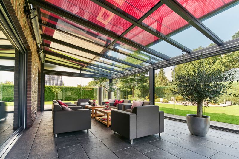 Interior view of a winter garden with red markilux on-glass awning.