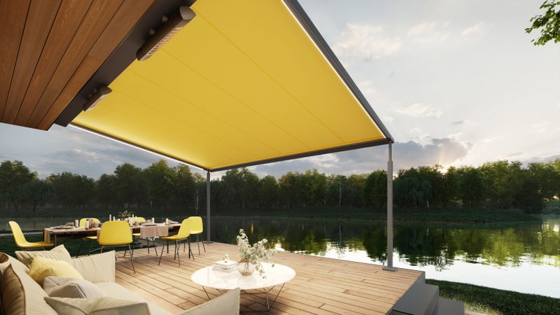 markilux pergola cubic con tela amarilla, iluminación y calefactores en una terraza junto al lago