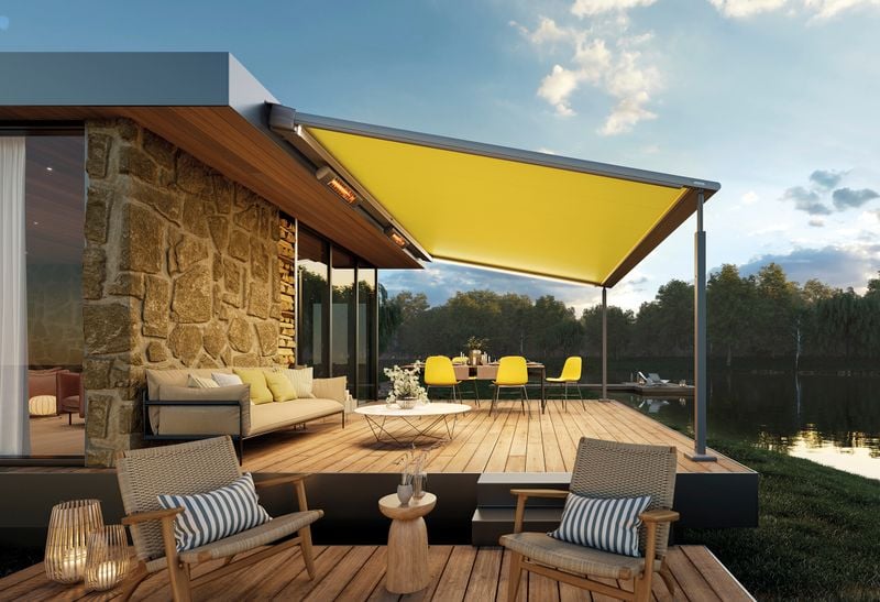 Pergola awning with yellow fabric cover and light gray frame in front of a lake
