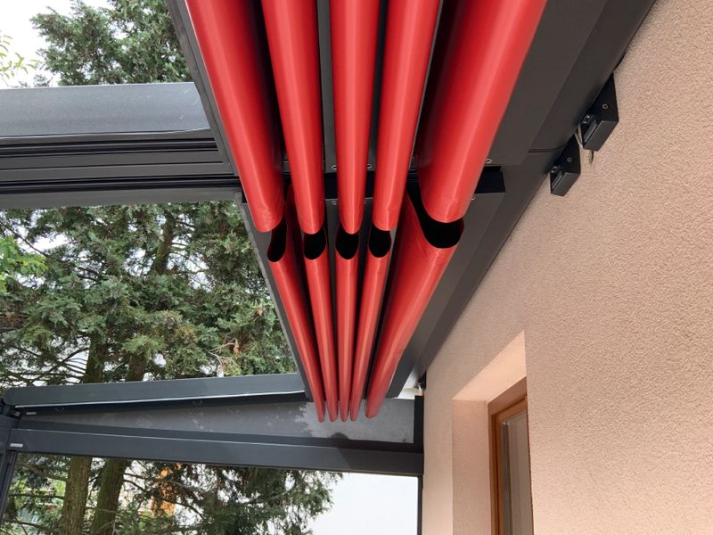 markilux pergola stretch detailed view: red fabric cover in retracted, folded state.