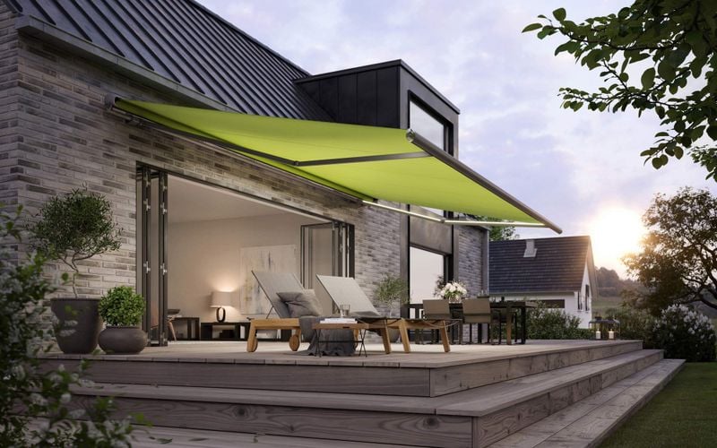 Einfamilienhaus mit breiter Fensterfront und ausgefahrener grünen mx 1600 Markise