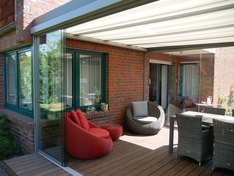 Conservatory equipped with markilux 879 under-glass awning with white fabric and vertical blind markilux 620 with gray fabric cover for sun and heat protection.