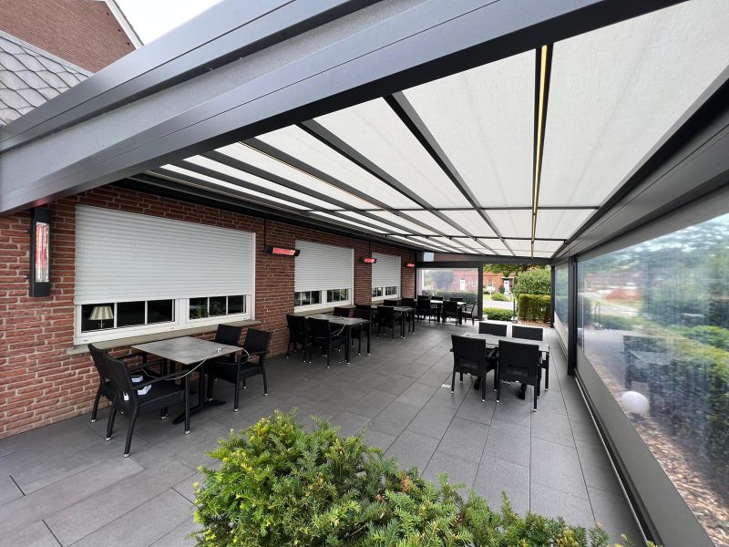 Combinatie van markilux pergola stretch met LED-Line en warmtestraler, wit doek en verticaal scherm met panoramaraam. Restaurant terras
