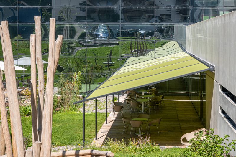 Imagem de referência de pérgula clássica com moldura de antracite e uma cobertura de tecido verde em frente a um terraço em Zell am See.