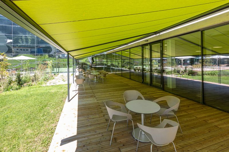 Reference image of the pergola classic with anthracite-colored frame and a green fabric cover in front of a terrace in Zell am See
