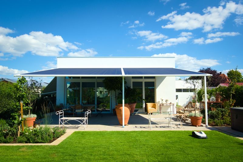 markilux pergola classic, telo della tenda da sole blu, casa bianca. protezione solare per terrazza in giardino.
