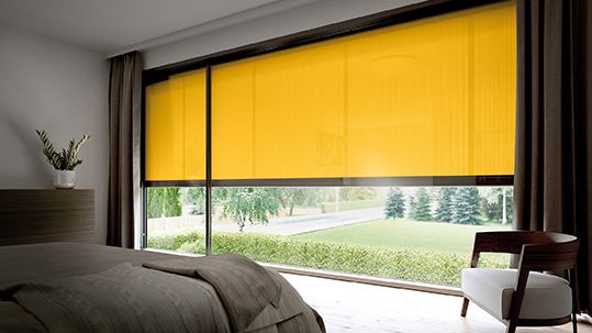 Toldo cofre vertical mx 620/625 en una amplia ventana de dormitorio con lona de tejido amarillo.