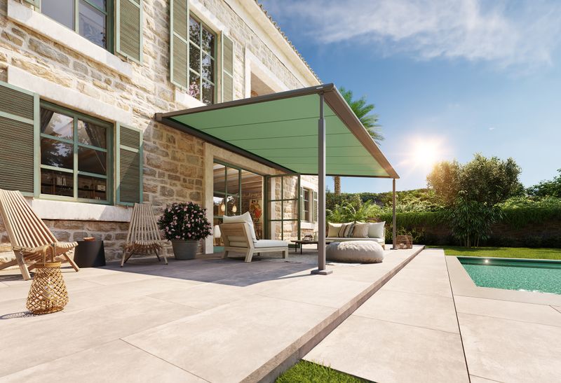 markilux pergola compact with turquoise fabric cover attached to a finca / sandstone house. A pool is located in front of the terrace.
