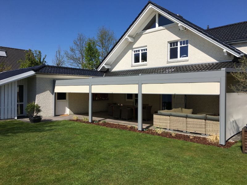 markilux pergola stretch with beige fabric combined with vertical awnings: reference object on a bright single-family house.