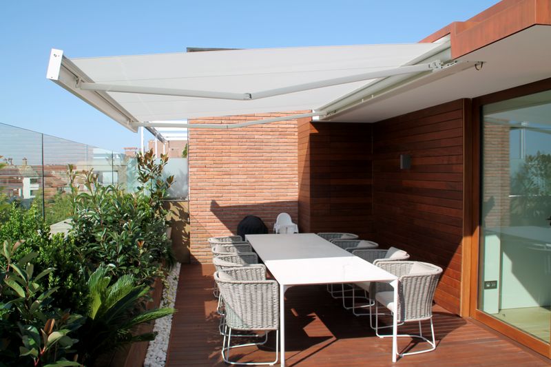 Cassette awning markilux 3300 with white fabric cover, niche installation on a balcony.