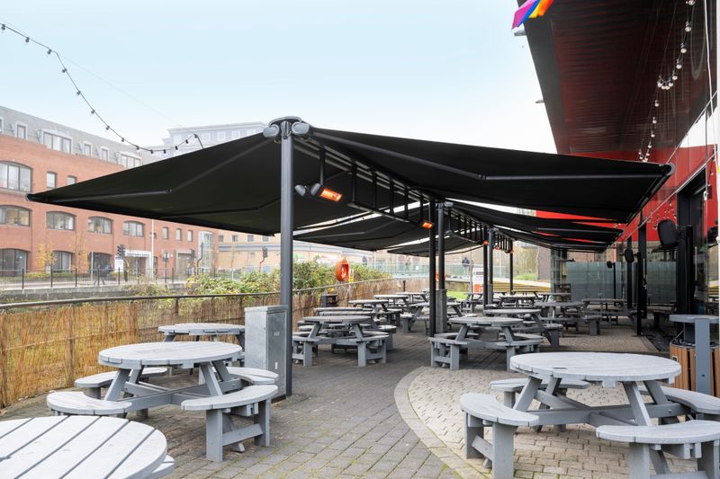 Reference picture: Several cassette awnings markilux 5010 (frame anthracite, fabric cover black) as double awning attached to stand system markilux syncra, equipped with infrared heaters.