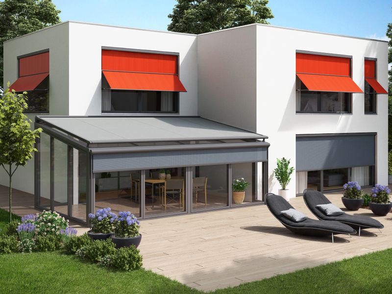 White flat roof house with conservatory awning equipped with different awnings: red marquisolette markilux 740 and gray conservatory awning.