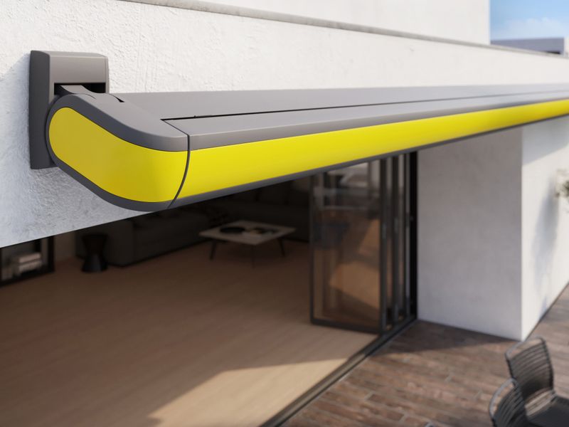 Detail view of a closed yellow cassette awning markilux MX-3 on a white house.
