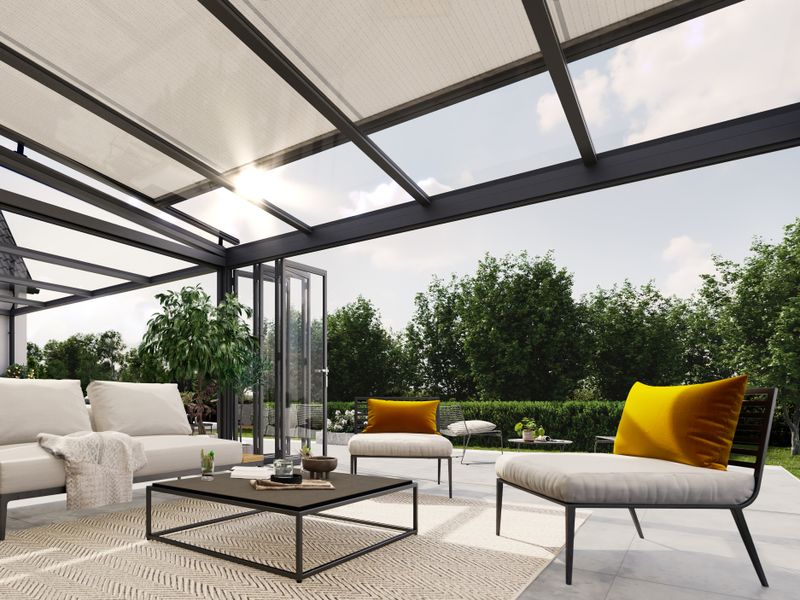 El toldo de cristal markilux 7800 top con lona del toldo de luz en un invernadero moderno hace que la terraza parezca una sala de estar al aire libre con zona de estar.