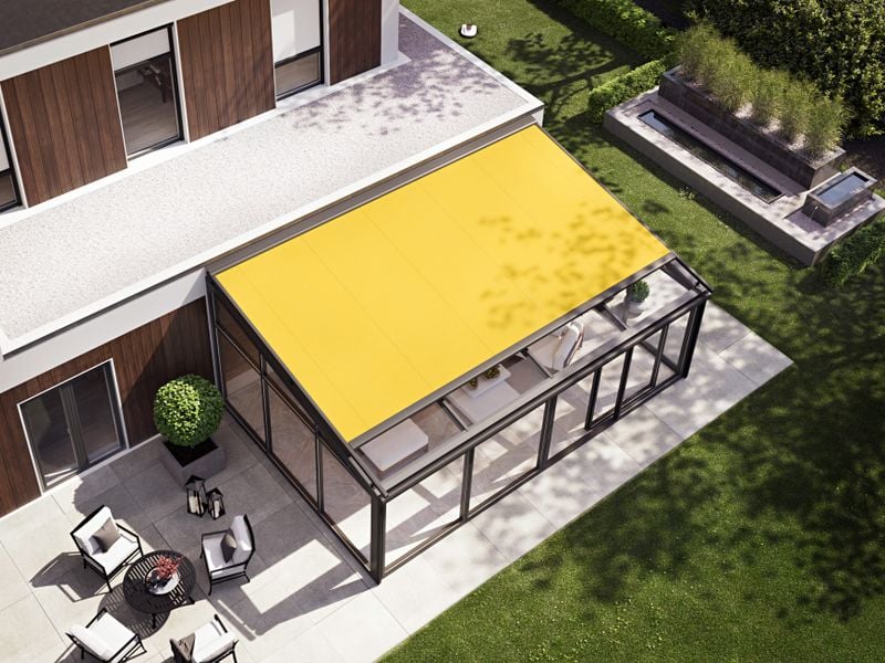 Bird's eye view of a markilux 8800 on-glass awning with yellow fabric cover, installed on a conservatory adjoining a wooden house.