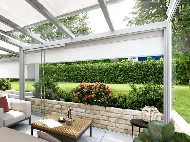 Shown is a winter garden, which is equipped with a white on-glass awning and provides shade.