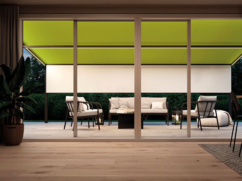View from the living room to the terrace, which is covered with terrace roof and markilux under-glass awning. Equipped with light green awning cover, shadeplus and lighting.
