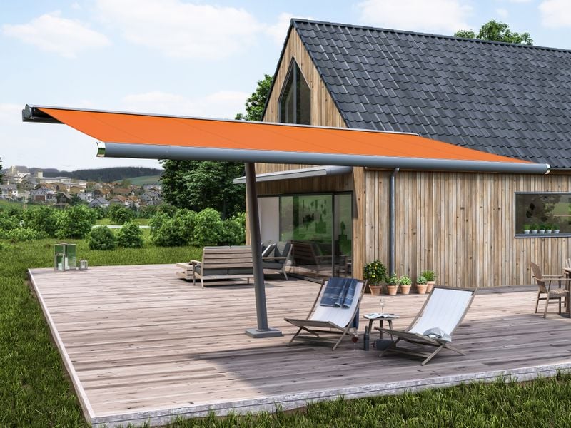 Store parasol markilux planet avec toile de store orange devant une maison en bois.