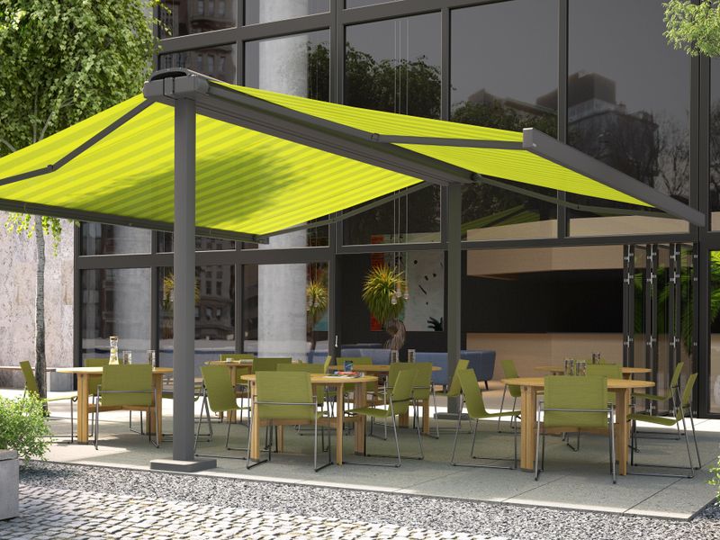 Free-standing double awning markilux syncra with green striped fabric cover for shading a restaurant terrace.