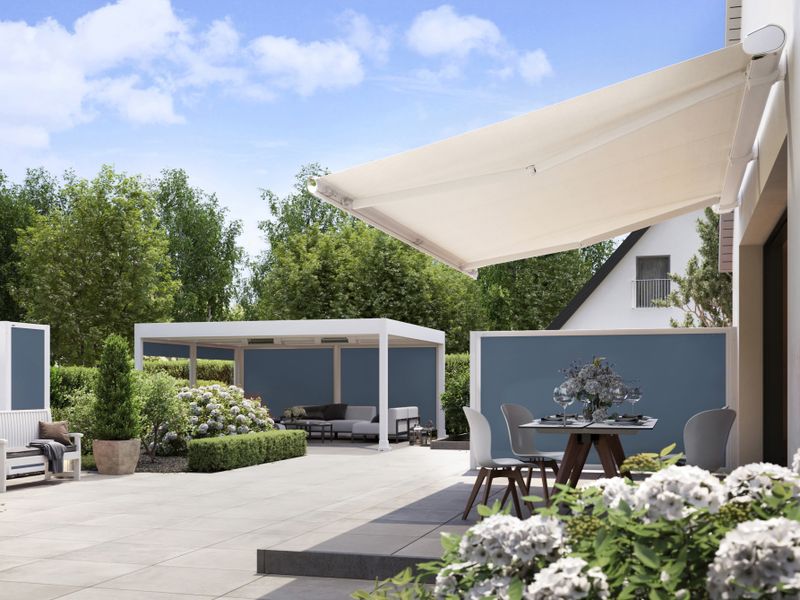 Garden with stone terrace and various seating areas. markilux awnings and screens protect the terrace.