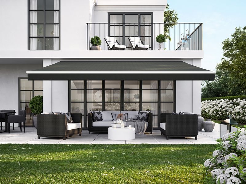 White urban villa with white awning markilux 1700 with black fabric cover and straight valance.