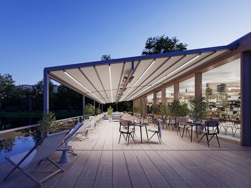 Terraza de restaurante junto al lago, cubierta con markilux pergola stretch con marco gris y tejido blanco. Escena por la noche con iluminación LED y radiadores de infrarrojos.