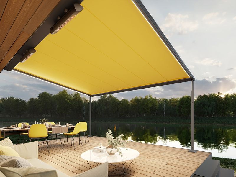 markilux pergola cubic con tela amarilla, iluminación y calefactores en una terraza junto al lago
