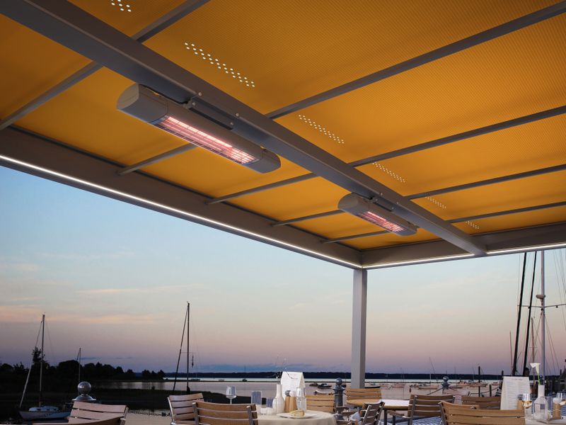 Awning canopy markilux markant with yellow fabric cover, equipped with lighting and infrared heater