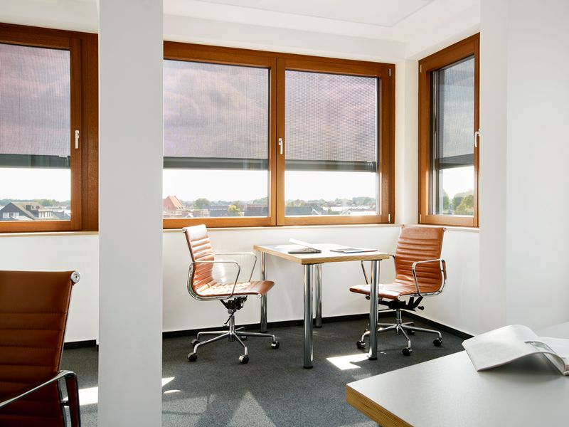 Referenzobjekt: Schreibtisch in einem Bürogebäude in unmittelbarer Nähe zu Fenstern, die über eine Fenstermarkise markilux 620 mit grauem, durchscheinenden Tuch verfügen.