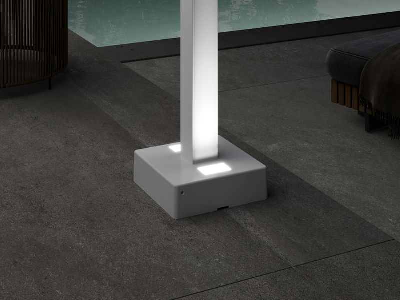 Detailed view of the foot cover of the markilux pergola style. LED uplights are integrated into the base and illuminate the support post of the pergola.