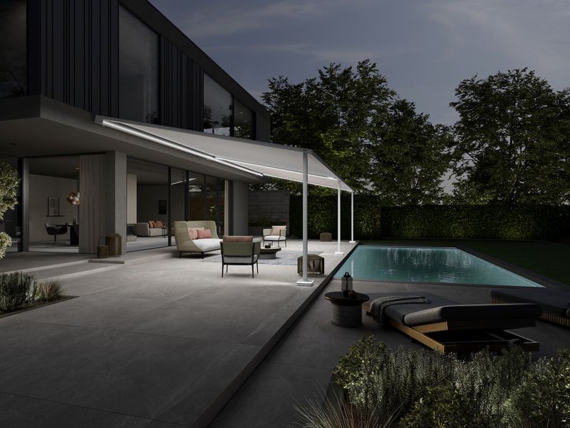 Pergola scherm markilux stijl op een modern, chique kubusgebouw. De verlichting van de pergola baadt het terras en de tuin met zwembad in prachtig licht.
