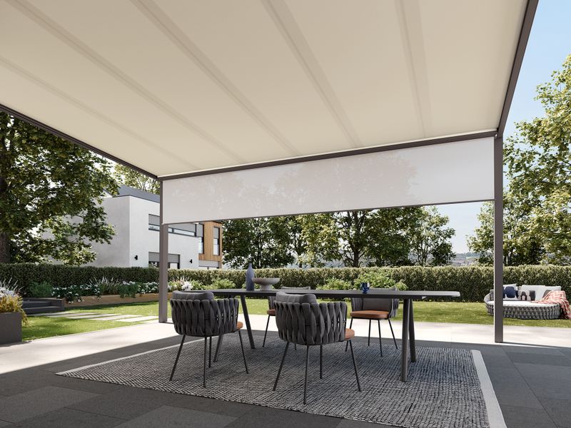 View below a white markilux 679 with a view of the spacious garden. Shadeplus is integrated into the front profile of the pergola to protect against low sun.