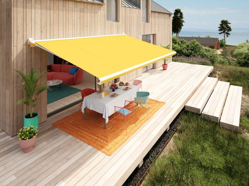The MX-3 with a golden yellow awning cover from the Popart Edition mounted on a Scandinavian-style house.