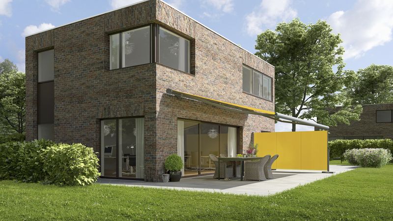 Extended mx 790 awning with yellow fabric cover and gray frame attached to a modern house.