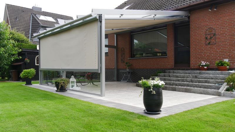 Terrassendach mit beiger markilux Unterglasmarkise und beiger Vertikalmarkise als seitlicher Sonnenschutz.
