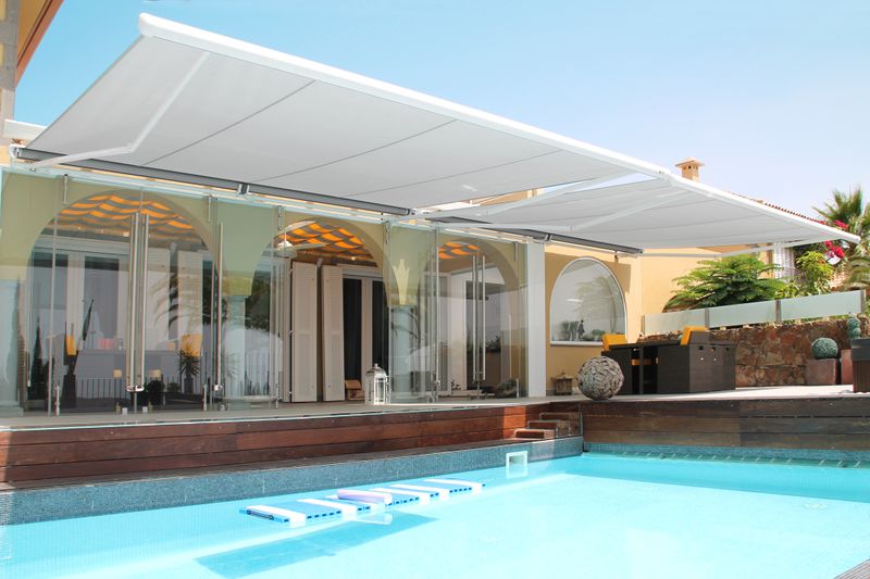 tenda da sole a semi-cassonetto markilux 1600 bianca su una casa con piscina a gran canaria