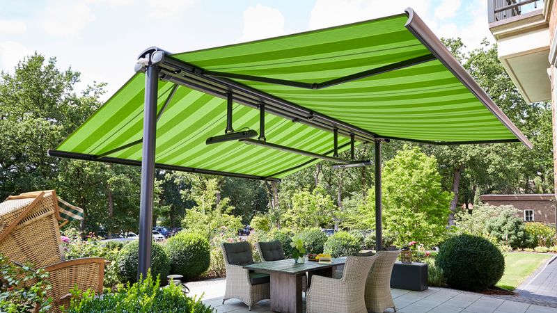 markilux syncra con toldo cofre markilux 5010 con lona verde montada en ambos lados.